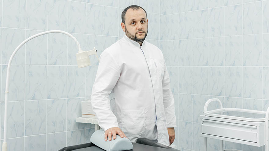Врач стоит в своем кабинете